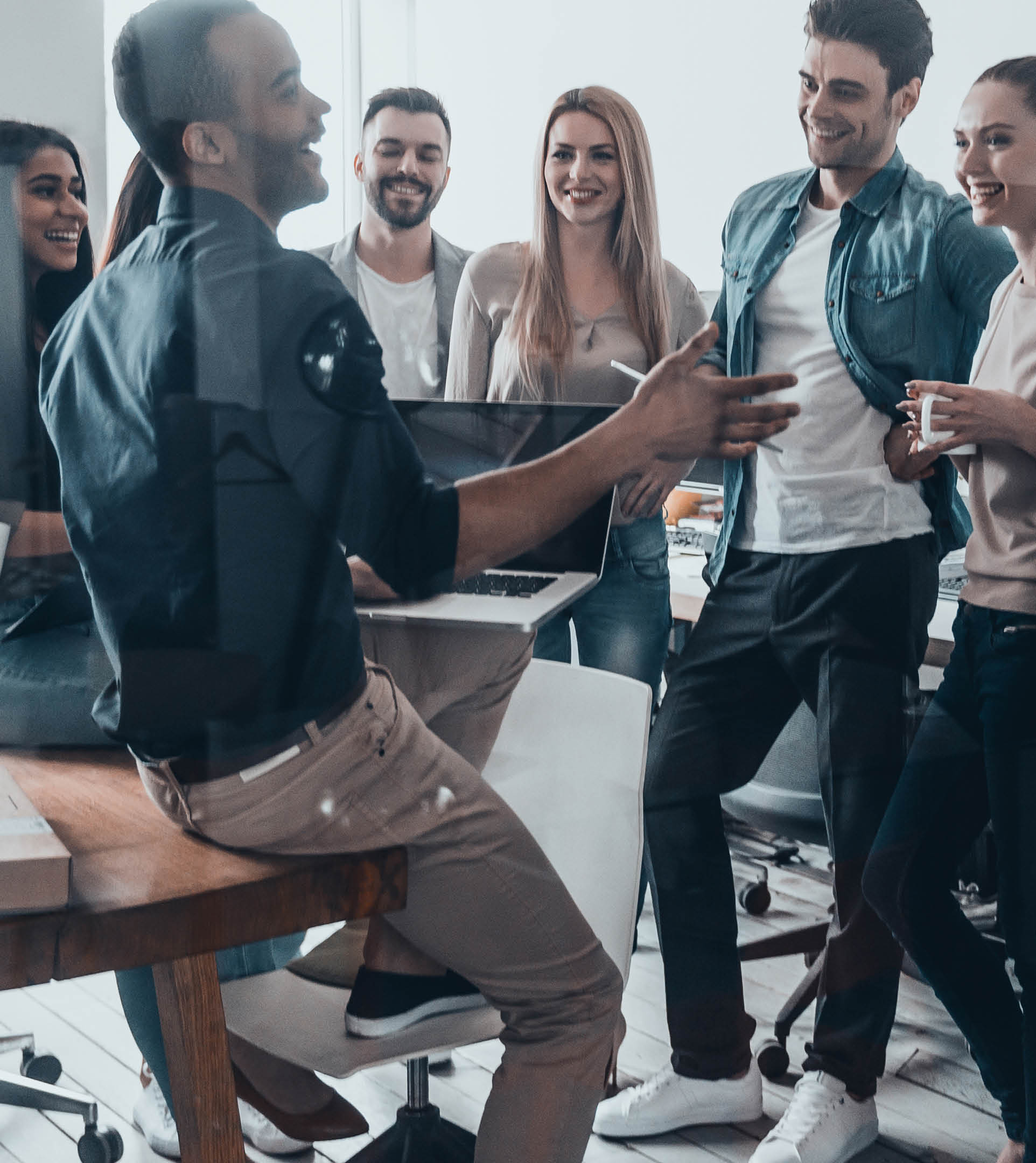 Young professional team   Group of young modern people in smart casual wear having a brainstorm meeting while standing behind the glass wall in the creative office